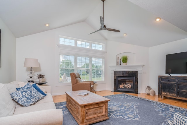 living room featuring high vaulted ceiling, a ceiling fan, wood finished floors, a fireplace, and baseboards