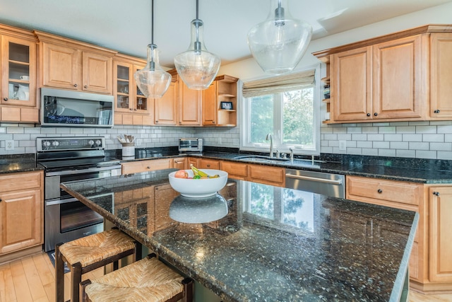 kitchen featuring open shelves, decorative backsplash, appliances with stainless steel finishes, and a sink