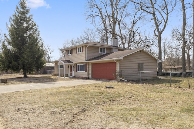 traditional-style home with an attached garage, fence, driveway, and a chimney