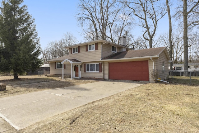 traditional-style home with fence, a garage, driveway, and a chimney