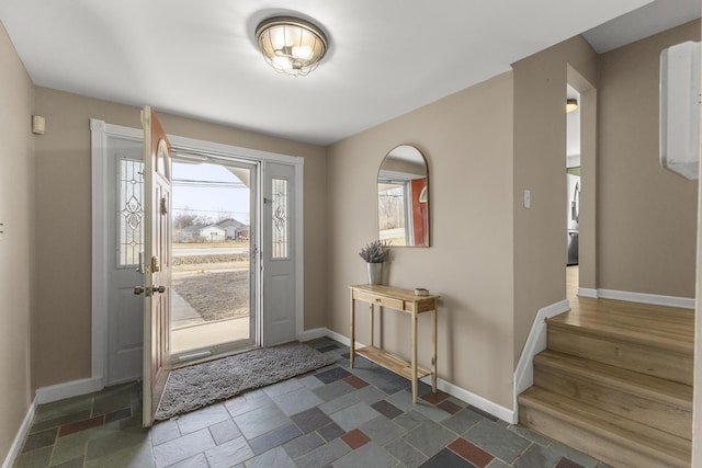 entrance foyer featuring stone finish floor and baseboards