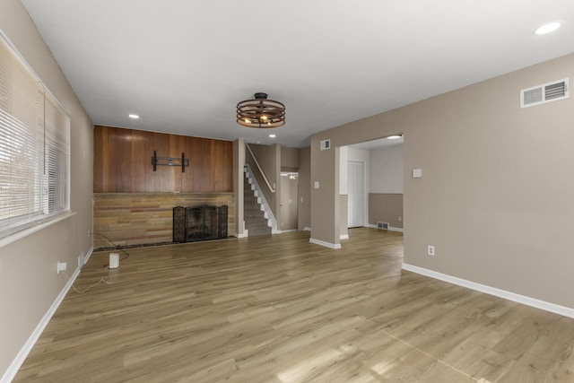 unfurnished living room with visible vents, recessed lighting, a fireplace, light wood finished floors, and baseboards