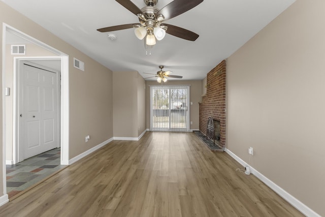 unfurnished living room with visible vents, baseboards, and light wood finished floors