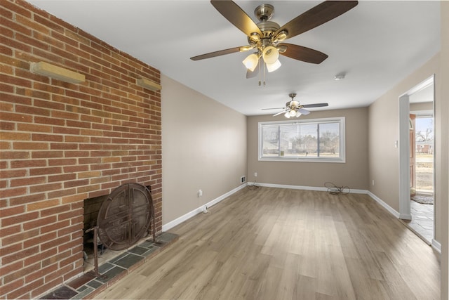 unfurnished living room featuring a healthy amount of sunlight, light wood-style floors, and baseboards