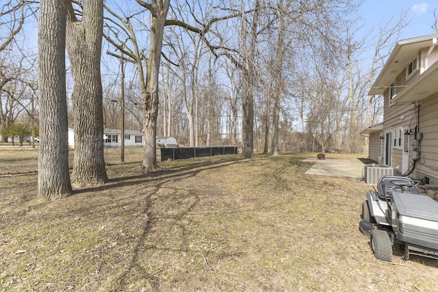 view of yard featuring central air condition unit and fence