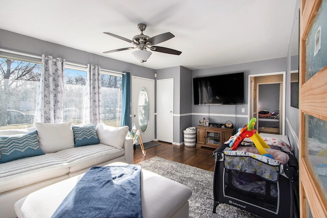 living area featuring plenty of natural light, wood finished floors, and a ceiling fan