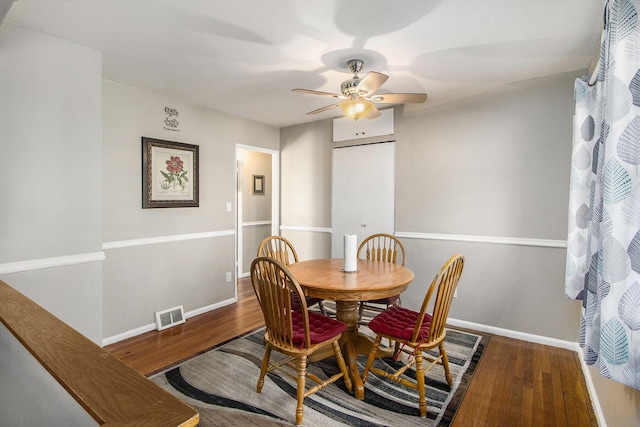 dining space featuring ceiling fan, wood finished floors, visible vents, and baseboards