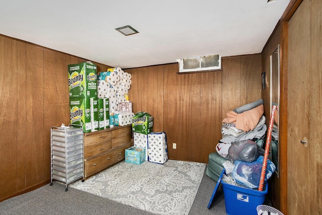 carpeted bedroom featuring wood walls