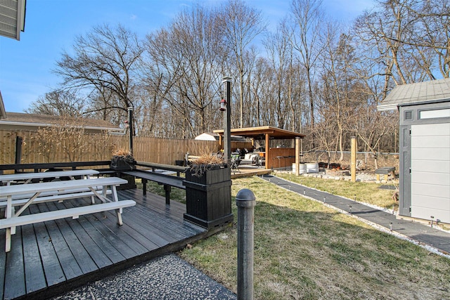 deck with a yard, an outdoor structure, and fence