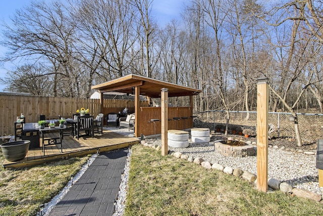 view of yard with a deck, a fire pit, and a fenced backyard