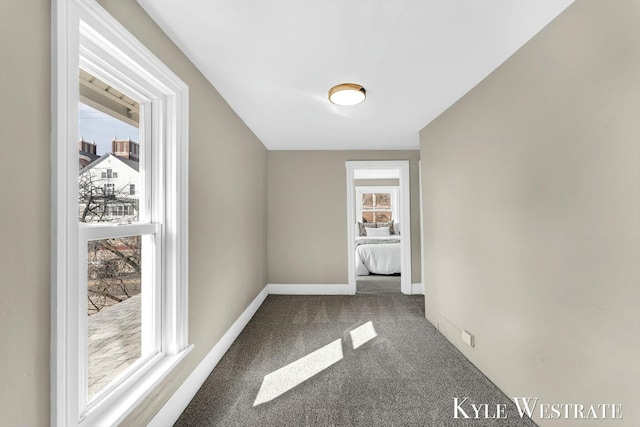 hall with baseboards and carpet floors