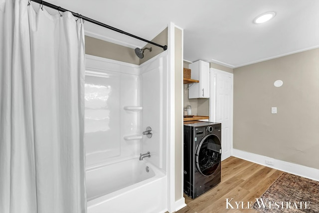 bathroom featuring washer / clothes dryer, shower / tub combo, baseboards, and wood finished floors