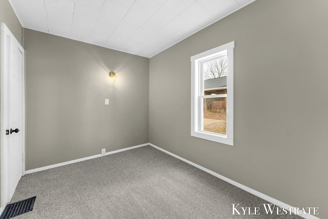 spare room featuring visible vents, baseboards, and carpet