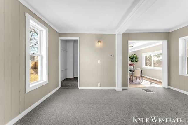 unfurnished room with visible vents, baseboards, crown molding, and carpet