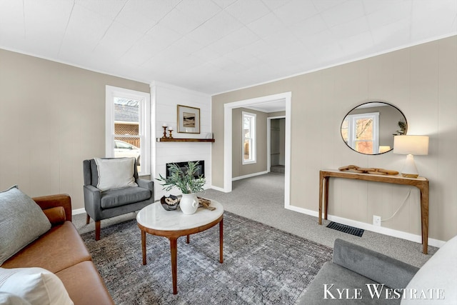 carpeted living room with baseboards and a large fireplace