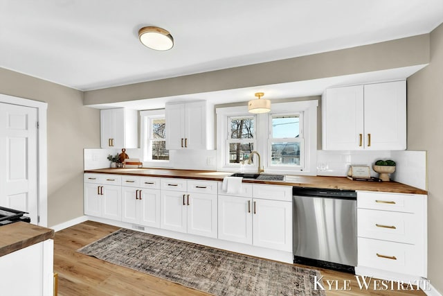 kitchen with dishwasher, light wood-type flooring, and butcher block countertops