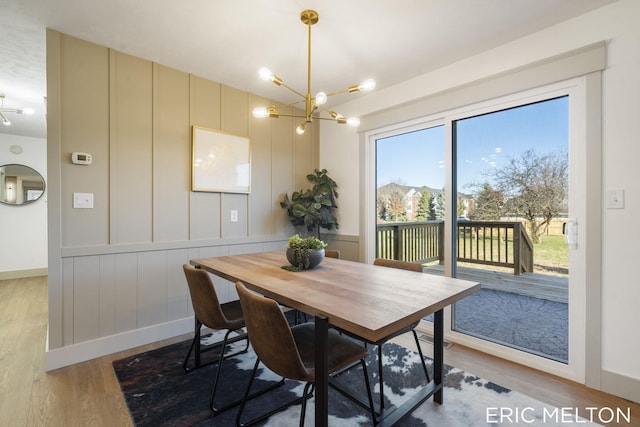 dining space featuring a notable chandelier, baseboards, and wood finished floors