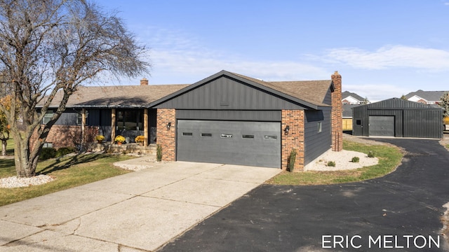 view of front of house with a chimney, concrete driveway, and a garage