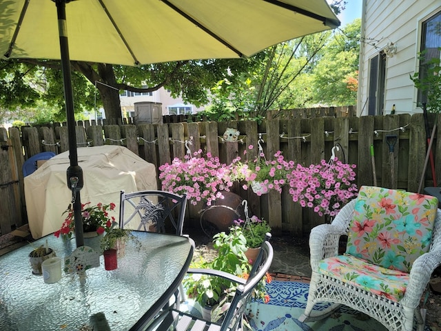 view of patio / terrace with a grill, outdoor dining area, and fence