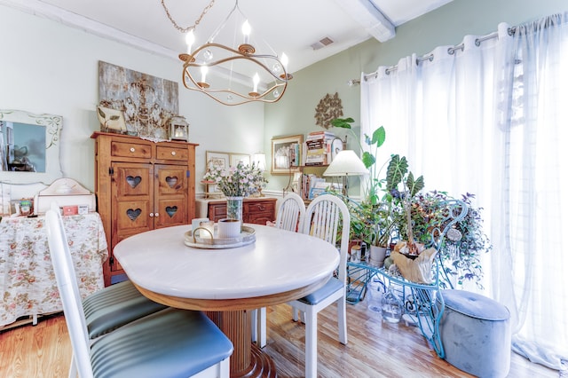 dining room with beam ceiling, a notable chandelier, light wood-style floors, and visible vents