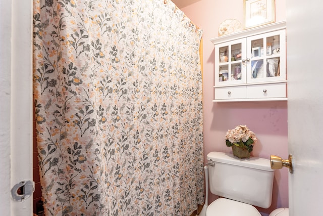 full bath featuring a shower with curtain and toilet