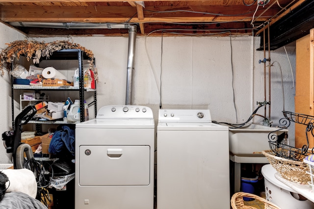 laundry room with laundry area, washing machine and dryer, and a sink