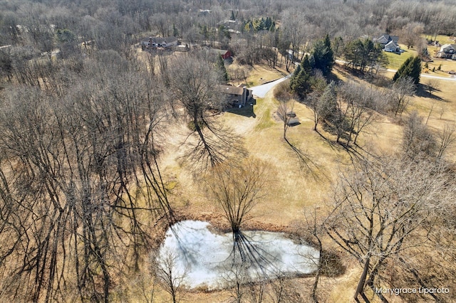 aerial view featuring a wooded view and a water view