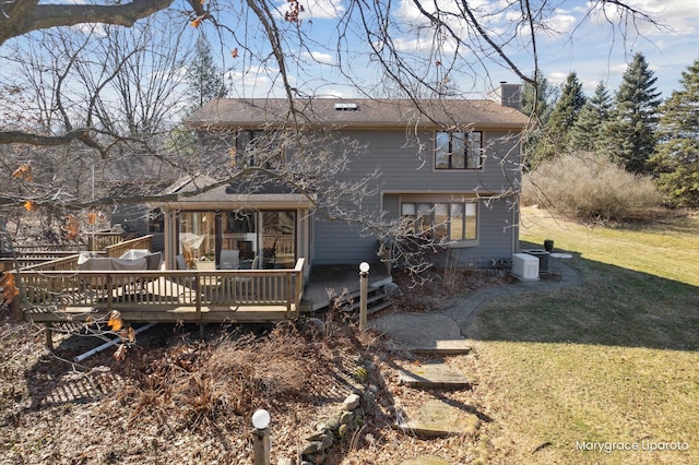 back of house with a yard, roof with shingles, a wooden deck, and a chimney