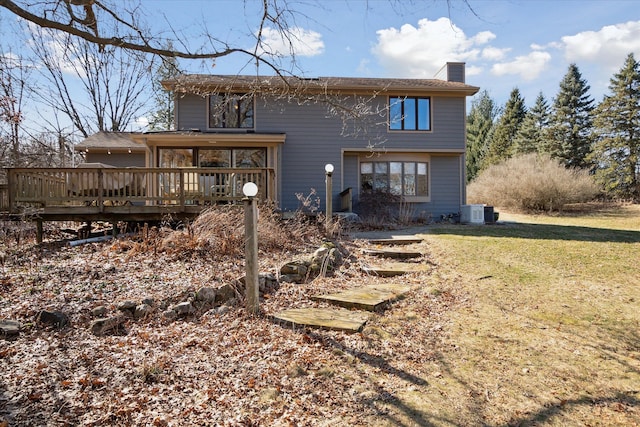 back of house with a deck, central air condition unit, a lawn, and a chimney