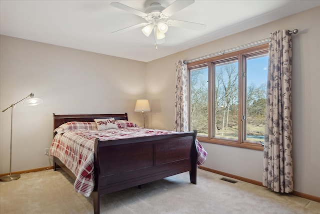 carpeted bedroom with multiple windows, visible vents, baseboards, and ceiling fan