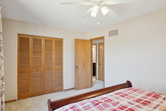 bedroom with baseboards, visible vents, ceiling fan, a closet, and light carpet