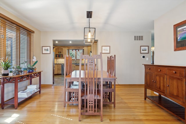 dining space featuring visible vents, light wood-type flooring, and baseboards