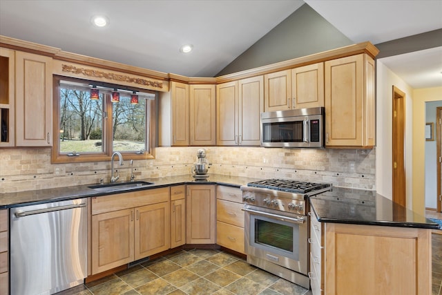 kitchen with vaulted ceiling, light brown cabinets, stainless steel appliances, and a sink