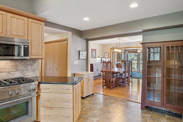 kitchen with tasteful backsplash, recessed lighting, light brown cabinets, and stainless steel appliances