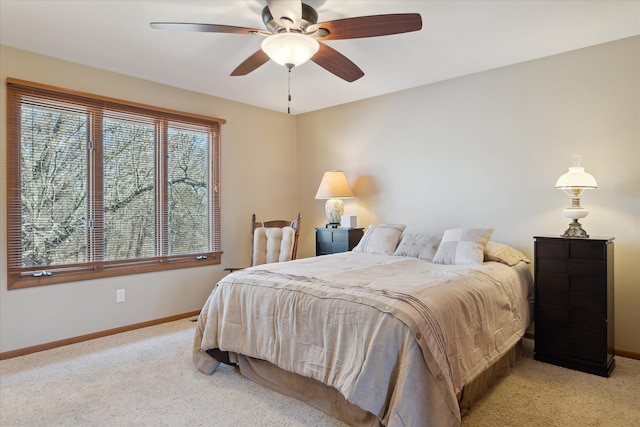 bedroom with light colored carpet, a ceiling fan, and baseboards