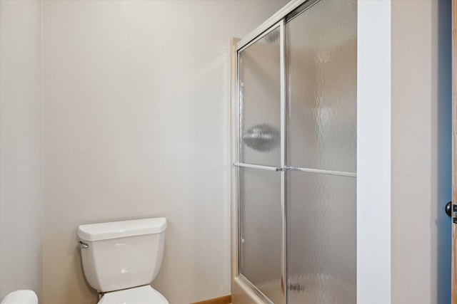 bathroom with toilet and a stall shower