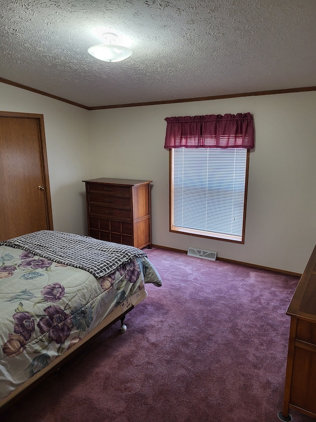 carpeted bedroom featuring visible vents, a textured ceiling, and ornamental molding