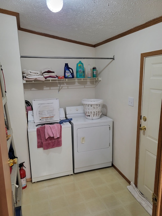 laundry room featuring ornamental molding, washer and clothes dryer, a textured ceiling, light floors, and laundry area