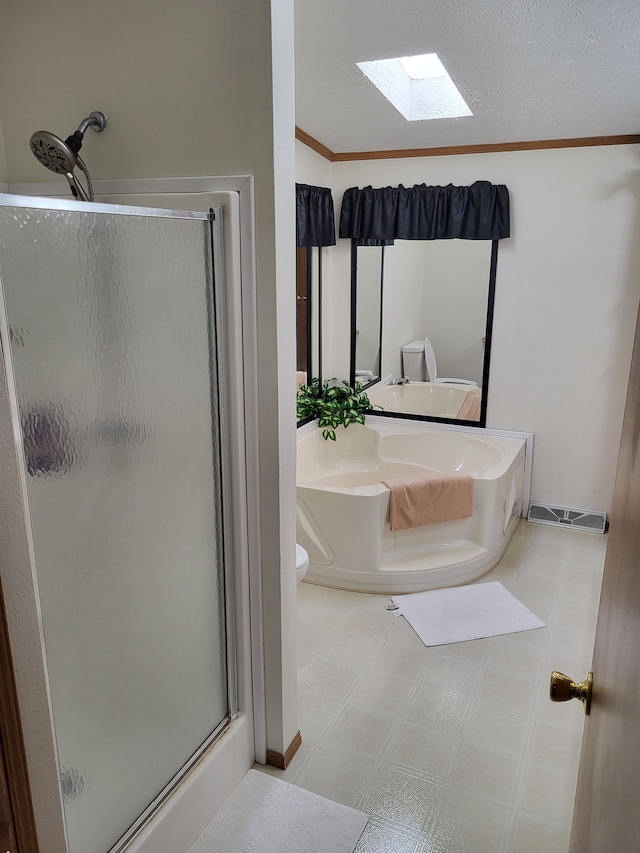 full bathroom with toilet, a stall shower, a skylight, tile patterned floors, and a textured ceiling