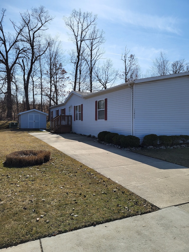 view of side of property featuring an outbuilding, a shed, and driveway