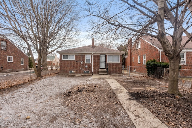 bungalow-style home featuring brick siding, fence private yard, entry steps, and a chimney