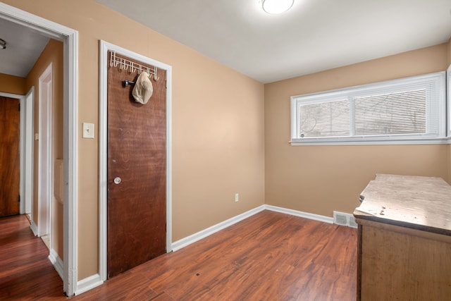 laundry area featuring visible vents, baseboards, and wood finished floors