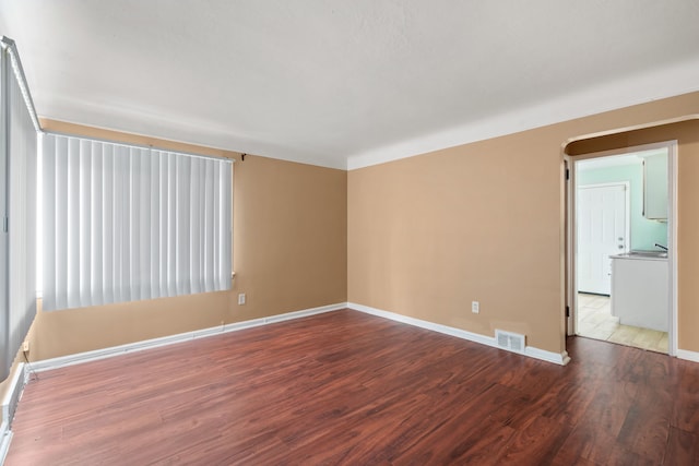 unfurnished room with visible vents, baseboards, and wood finished floors