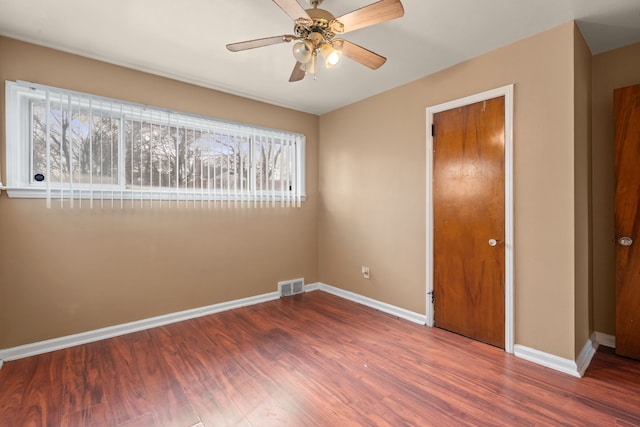 unfurnished bedroom with visible vents, baseboards, and wood finished floors