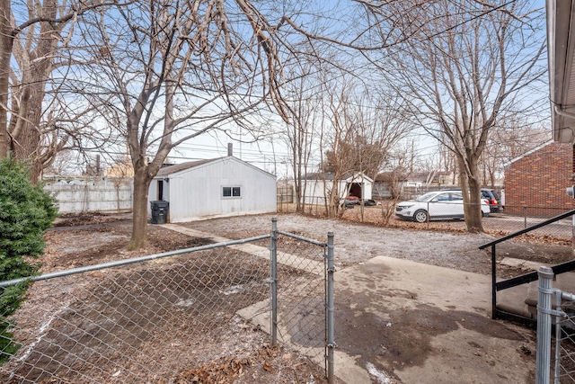 view of yard with an outdoor structure, a gate, and fence