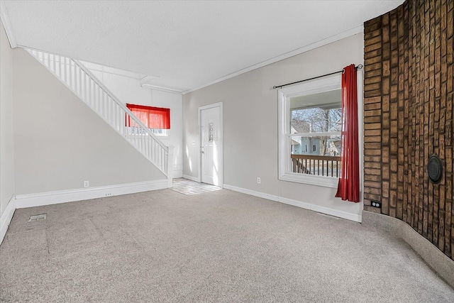 unfurnished living room featuring stairs, baseboards, carpet floors, and crown molding