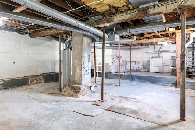 unfinished below grade area featuring water heater and washing machine and clothes dryer