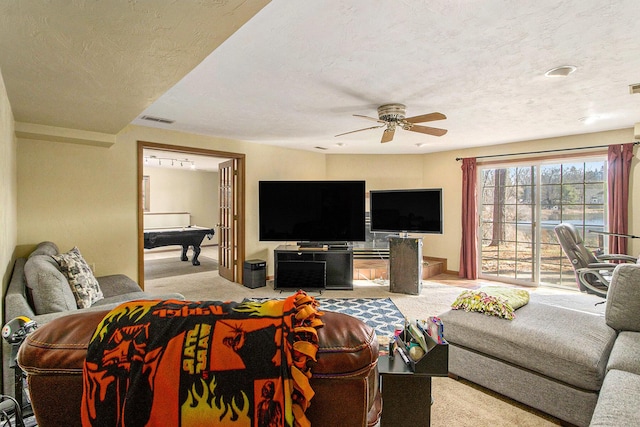 carpeted living room with visible vents, a textured ceiling, and ceiling fan