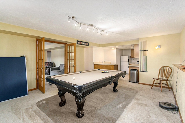 recreation room with light colored carpet, baseboards, a textured ceiling, and pool table