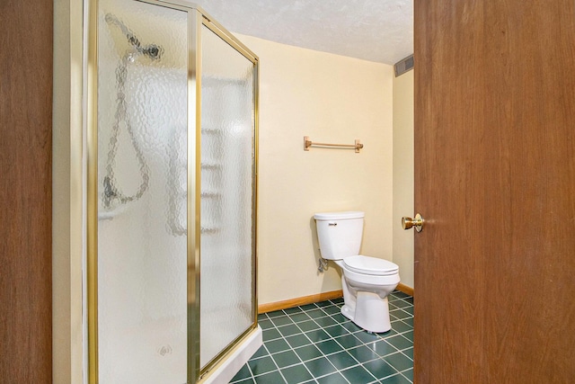 full bath featuring a shower stall, baseboards, toilet, tile patterned floors, and a textured ceiling